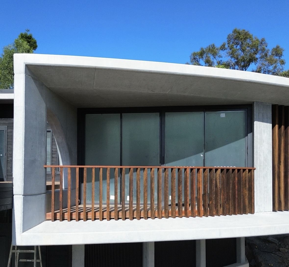 Close view of a hardwood balustrade on a concrete balcony