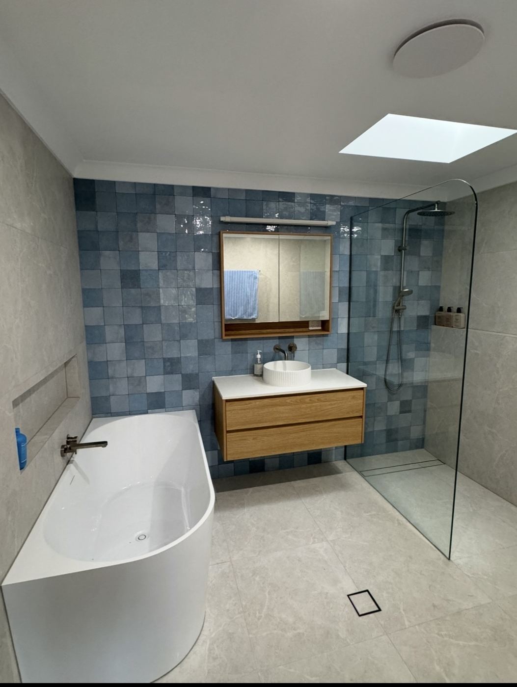 Bathroom with blue square feature tiles, timber vanity and walk-in shower