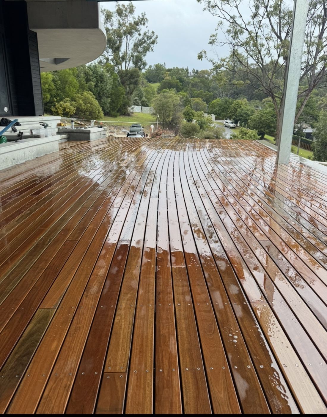 Large hardwood deck freshly oiled after rain